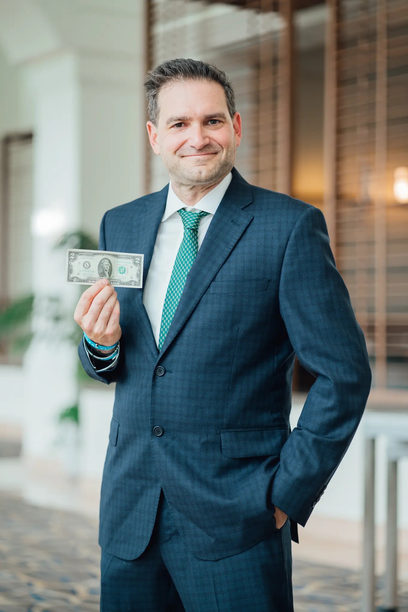 Brad Holcman holding a $2 bill
